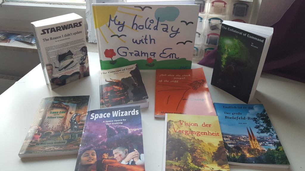 9 books are arranged on a table. They range from picture book to bound fanfic.
